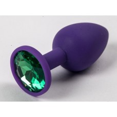 Фиолетовая силиконовая анальная пробка с зеленым стразом - 7,1 см.